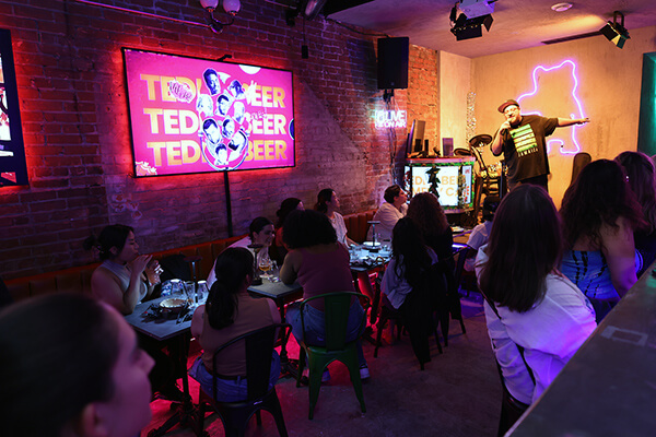 Comedy night at Teddy Beer bar in Toronto with comedian performing on stage and audience enjoying the show