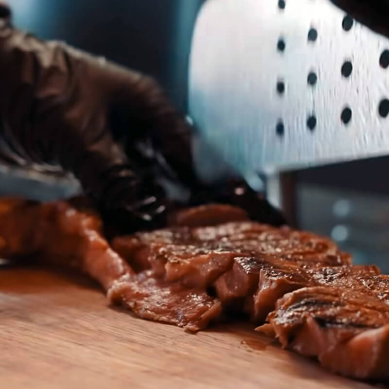 Close-up of a chef slicing a juicy steak at Teddy Beer bar in Toronto