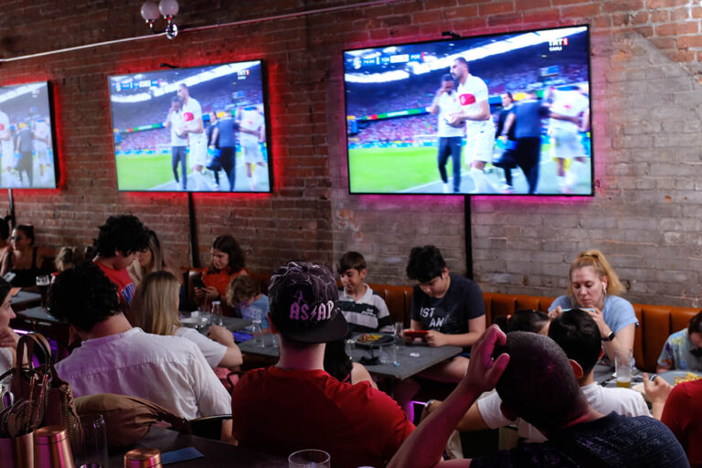 Audience watching the Turkey vs Portugal football match at Teddy Beer with multiple screens and a lively atmosphere.